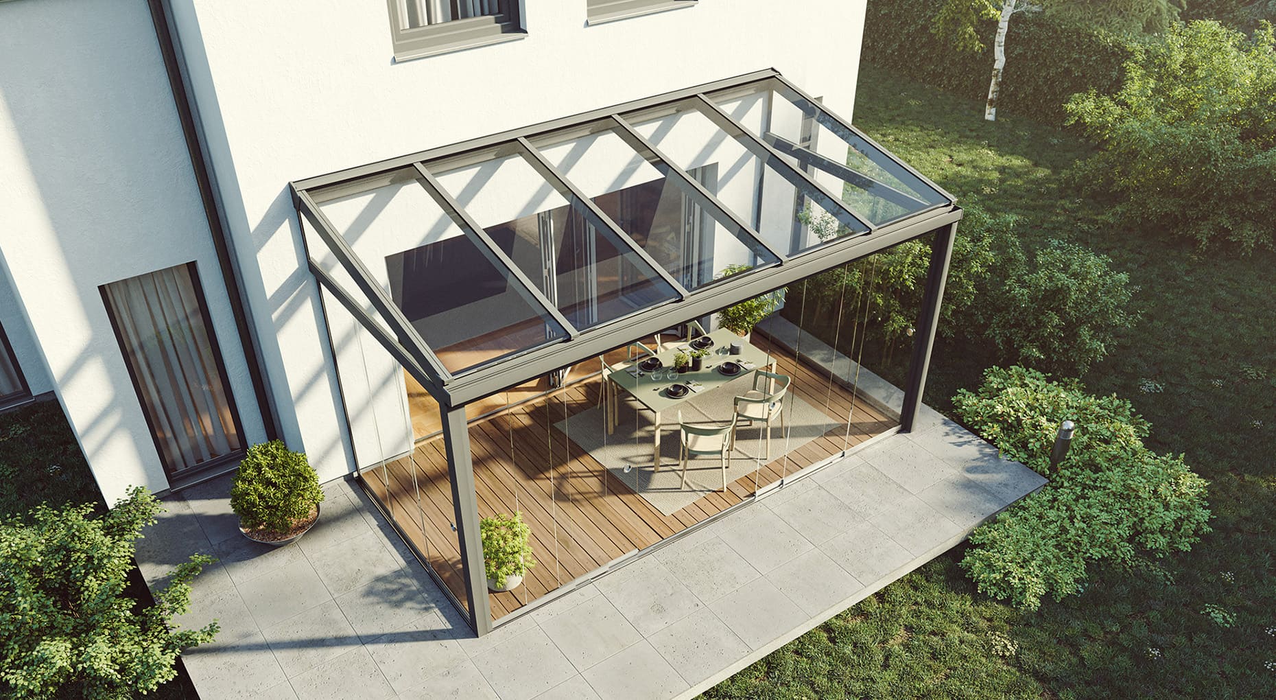Moderner Wintergarten mit Glasdach und Glaswänden an einem weißen Haus, mit Esstisch und Stühlen auf Holzterrasse