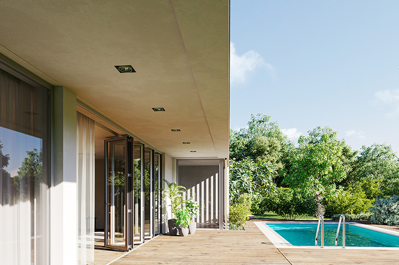 Terrasse mit Holzbelag, Glas-Schiebetüren von Sunflex SF55, Blick auf Garten mit Bäumen und Schwimmbecken