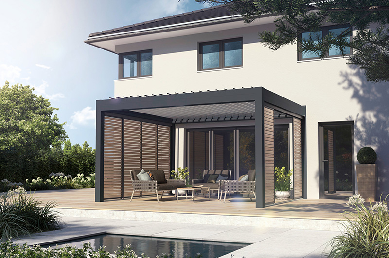 Moderne Terrasse mit grauer Überdachung aus Metall und Holzlamellen an einem weißen Haus, ausgestattet mit Sitzmöbeln und Blick auf einen Pool